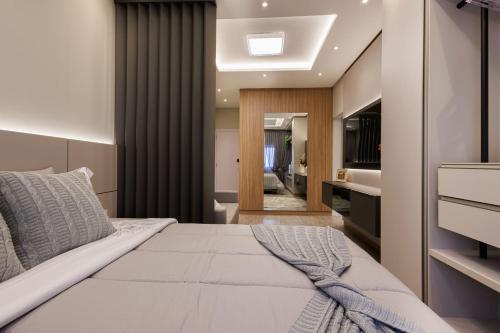 a bedroom with a large white bed and a bathroom at Apartamento 401 wiithhoeftf in Pomerode