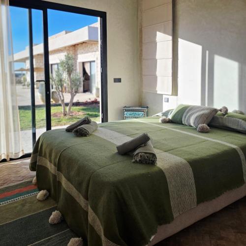 a bedroom with a large bed with a large window at Tempo Vegan B&B in Essaouira