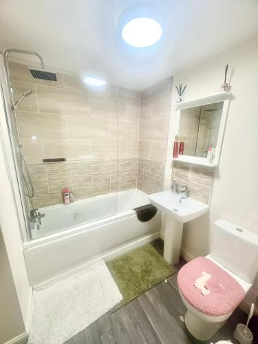 a bathroom with a tub and a toilet and a sink at Quiet and Comfortable Double guest room in Nuneaton