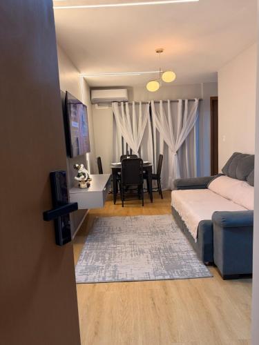 a living room with a bed and a dining room at Ponta Negra Apartment in Manaus