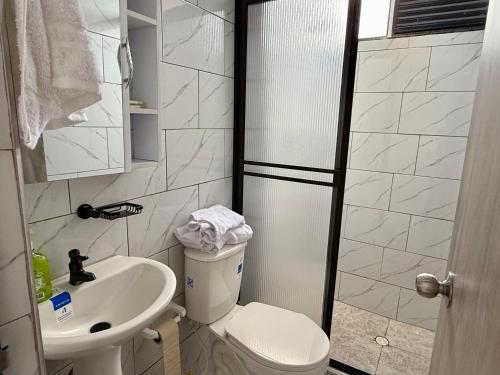 a bathroom with a toilet and a sink at Apartamento nuevo en La Patria in Armenia