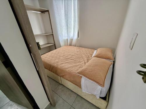 a small bed in a small room with a window at Apartamento nuevo en La Patria in Armenia