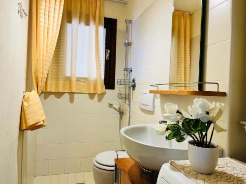 een badkamer met een witte wastafel en een toilet bij GuestHost - Petite Fleur - Cozy La Thuile Flat in La Thuile