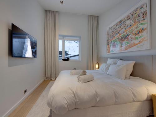 sypialnia z białym łóżkiem z pluszowym misiem w obiekcie Appartement de luxe à Tignes avec jacuzzi et parking, pour 12 pers. - FR-1-641-117 w mieście Tignes
