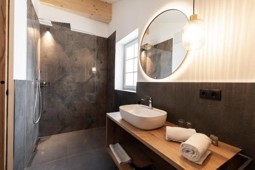 un bagno con lavandino e doccia con specchio di Garni Hotel Tauber a Bressanone