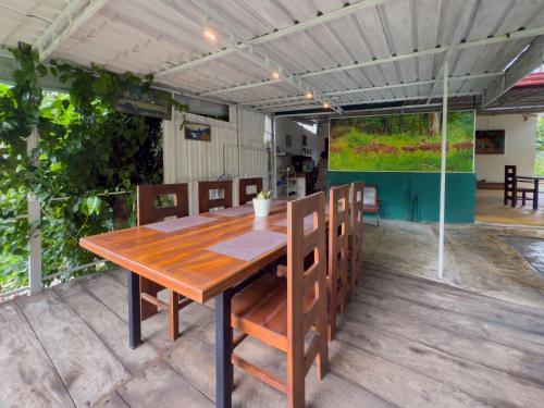 un tavolo e sedie di legno su un patio di JAMI River Side Hotel & Yala Safari Place a Tissamaharama