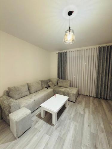 a living room with a couch and a coffee table at Modern 2-Bed Near Tirana and Airport with Balconies in Kamëz