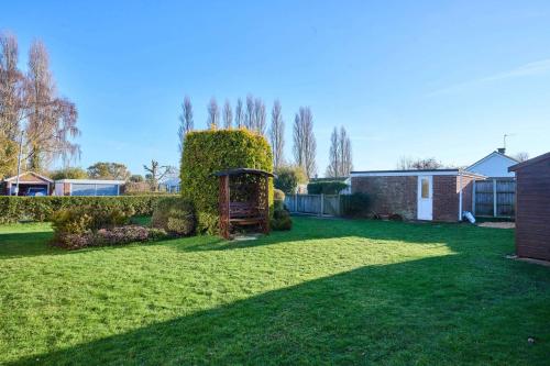 een tuin met een groen gazon met een struik bij Host & Stay - WillowStay in Martham