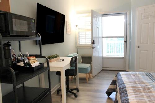 a small room with a desk and a bed and a window at Beach Bungalow by Coastal Concierge in Sunset Beach