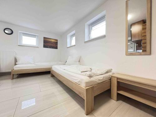 a room with two beds and two benches in it at STB116 smarte Monteurwohnung in Steinberg