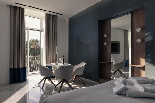 a bedroom with a bed and a table and chairs at ViaRomaHome - Salerno in Salerno