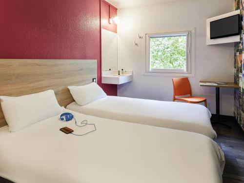 um quarto de hotel com duas camas e uma pia em hotelF1 Rouen Zénith Parc Expo em Saint-Étienne-du-Rouvray