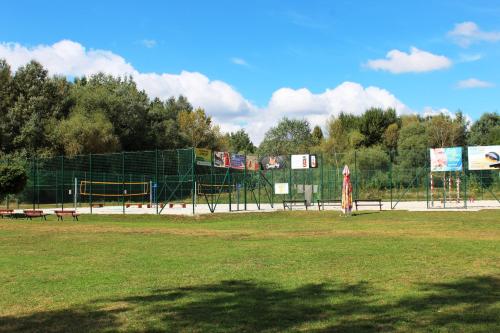 a park with a playground with a fence and benches at Apartment Promenada in Poděbrady
