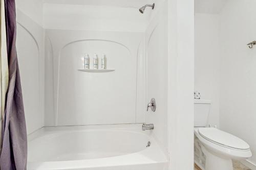 a white bathroom with a tub and a toilet at Equipe Sport 2E in Dover