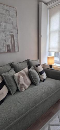 a couch with pillows on it in a living room at Les Murs By le Clos in Metz