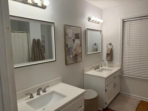 a white bathroom with two sinks and a mirror at Marion Getaway in Marion