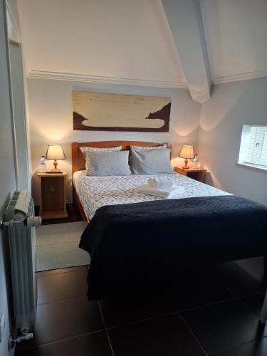 a bedroom with a large bed with two lamps at Guesthouse Veríssimo in Nazaré