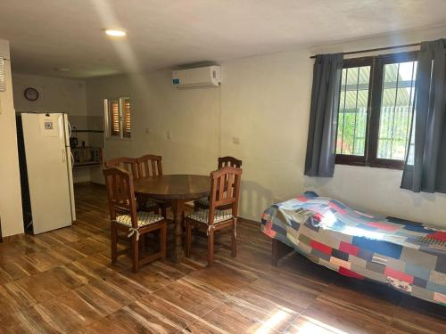 a kitchen with a table and chairs and a bed at Cabaña El Quebrachal in Valle Hermoso