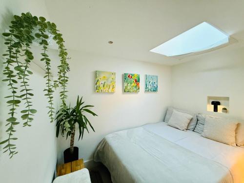 a bedroom with a bed and a potted plant at Stunning, architecturally designed Garden Studio with Parking in London