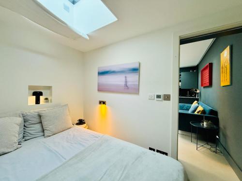 a bedroom with a white bed in a room at Stunning, architecturally designed Garden Studio with Parking in London