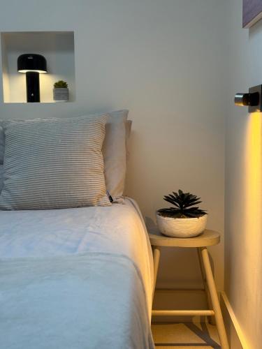 a bedroom with a bed and a table with a plant on it at Stunning, architecturally designed Garden Studio with Parking in London