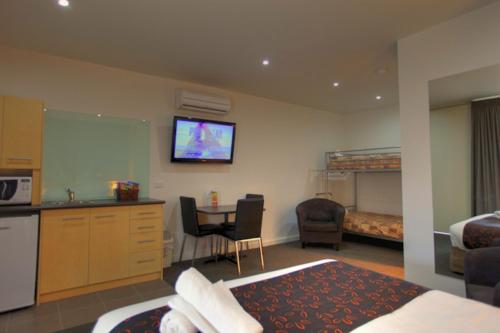 a hotel room with a bedroom with a bed and a kitchen at Mansfield Motel in Mansfield