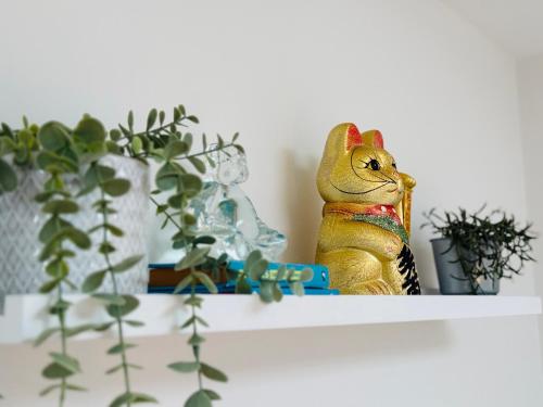 a toy rabbit sitting on a shelf with plants at Stunning, architecturally designed Garden Studio with Parking in London