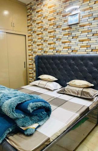 a bed with a blue blanket on top of it at The Healing Haven in Kharar