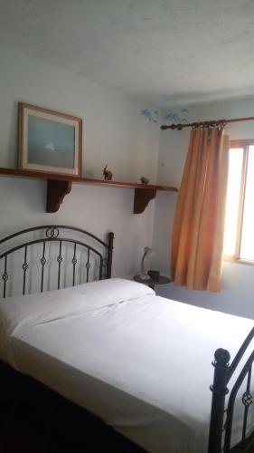 een slaapkamer met een wit bed en een raam bij Holiday Home Golfo di Orosei Cala Gonone in Cala Gonone
