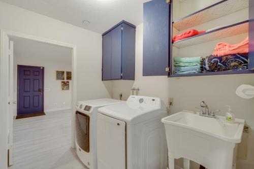 a laundry room with a sink and a washing machine at The Maharaja Retreat with Hot Tub and EV Charger! in Yucca Valley