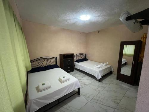 a bedroom with two beds and a mirror at Casa en Cuautla, Morelos 