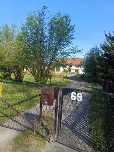 a fence with the on it in a yard at Agroturystyka Przy Stajni in Zbylutów