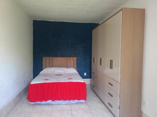 une chambre avec un lit avec un couvre-lit rouge dans l'établissement Hospedaria da Gabi, à São Pedro da Aldeia