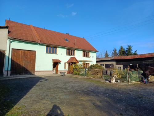 a house with a fence and a dog in front of it at Agroturystyka Przy Stajni in Zbylutów
