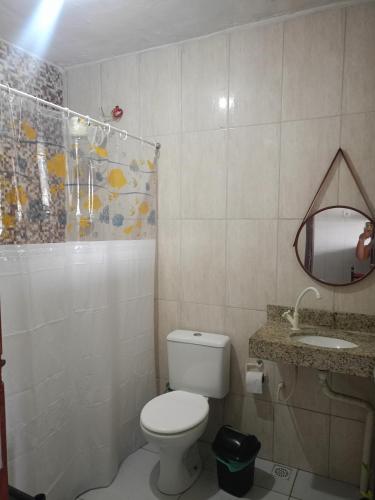 a bathroom with a toilet and a sink and a mirror at Hospedaria D' Gabi in São Pedro da Aldeia