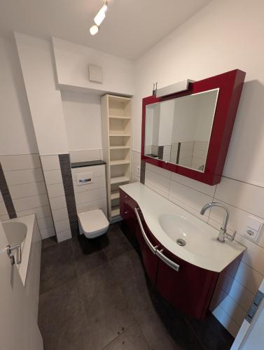 a bathroom with a sink and a mirror and a toilet at Large city apartment with beautiful views in Marburg an der Lahn