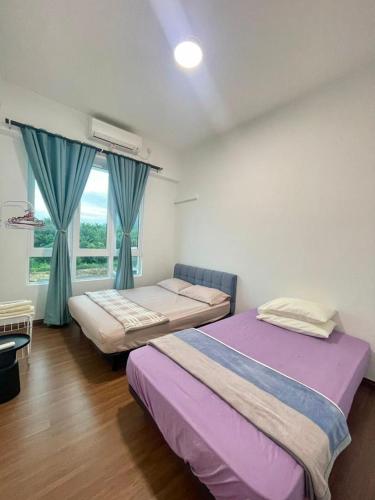 a bedroom with two beds and a window at Jhomestay2 in Sandakan