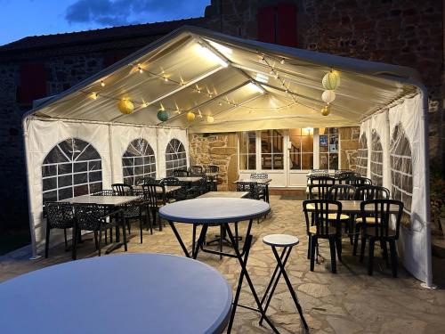 a group of tables and chairs under a tent at Chambre Château in Augnat