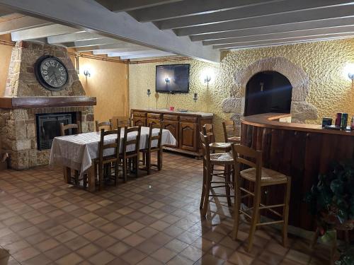 a restaurant with a table and chairs and a clock at Chambre Château in Augnat