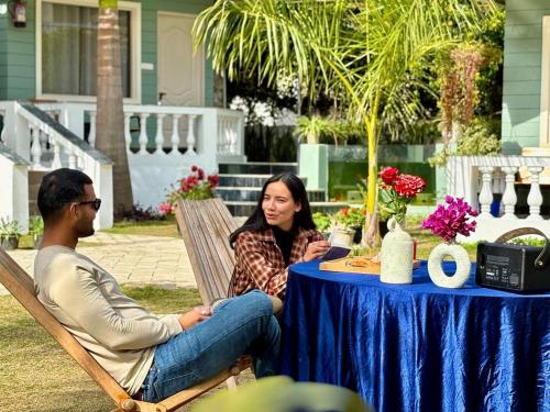 a man and a woman sitting in a chair at a table at Glampers Resort Rishikesh at River Side in Rishīkesh