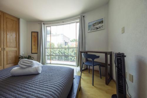 a bedroom with a bed and a desk and a window at Casa Hidalgo By Mi Querido Coyoacán in Mexico City