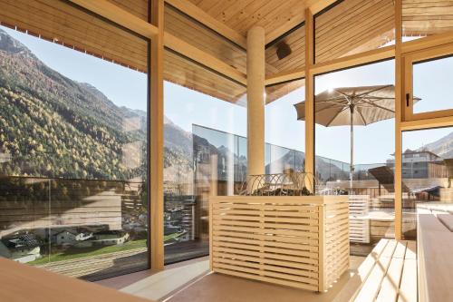 a dining room with large windows and views of mountains at Lärchenlodge SkySpa and Rooftop Pool inklusive Stubai SuperCard in Fulpmes