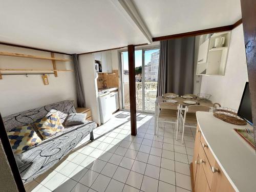 Studio CAP D'AGDE CT375-058 في كاب داغد: مطبخ وغرفة معيشة مع أريكة وطاولة