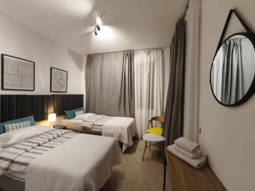 ein Hotelzimmer mit zwei Betten und einem Spiegel in der Unterkunft Danaos Nava in Paphos City