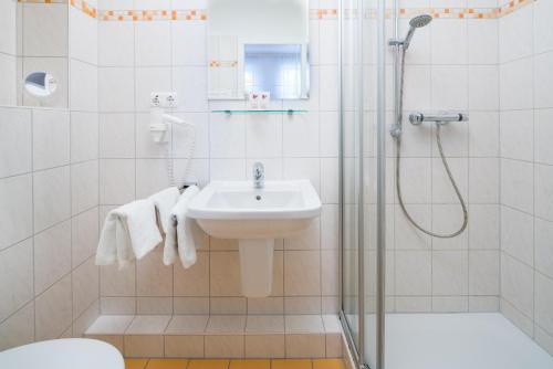 a bathroom with a sink and a shower at Hotel Flora in Bad Harzburg