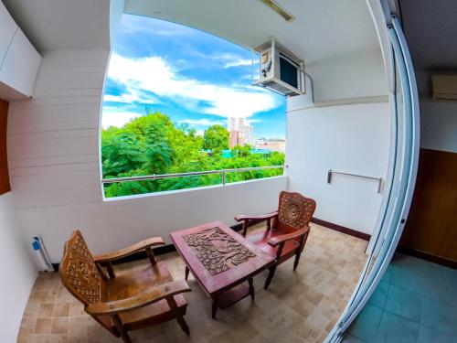 a room with a window and two chairs and a table at Luna Hut Resort in Hua Hin
