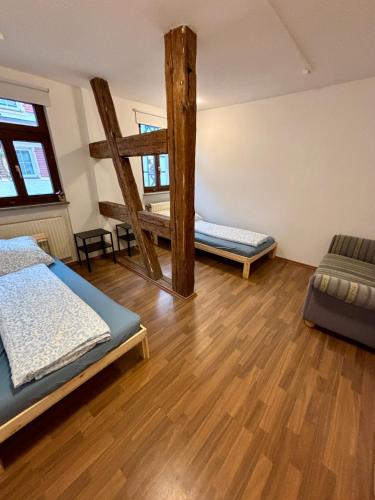a room with two beds and a wooden floor at Herzo City Apartment - bis zu 8 Personen - 4 Schlafzimmer - Innenstadt in Herzogenaurach