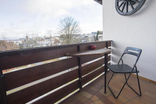 a chair and a table on a balcony with a window at Welcome in - Appartement centraal gelegen met balkon - Heidestrasse 2 Winterberg in Winterberg