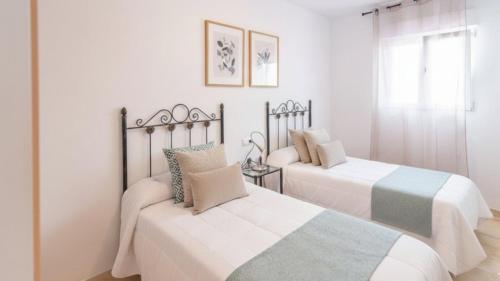 zwei Betten in einem Schlafzimmer mit weißen Wänden in der Unterkunft Villa Paraiso Torrox by Ruralidays in Torrox