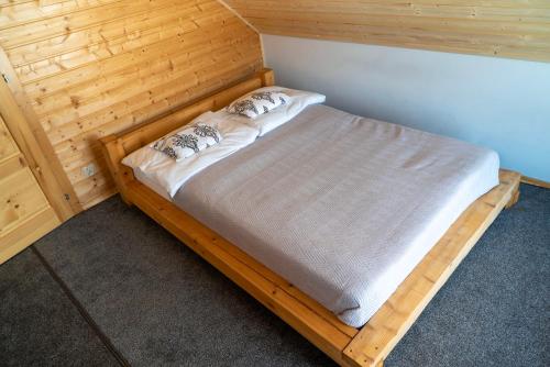 una camera da letto con un letto di legno in una stanza di Widokowe Stodoły balia z hydromasażem na wylączność a Chyżówki